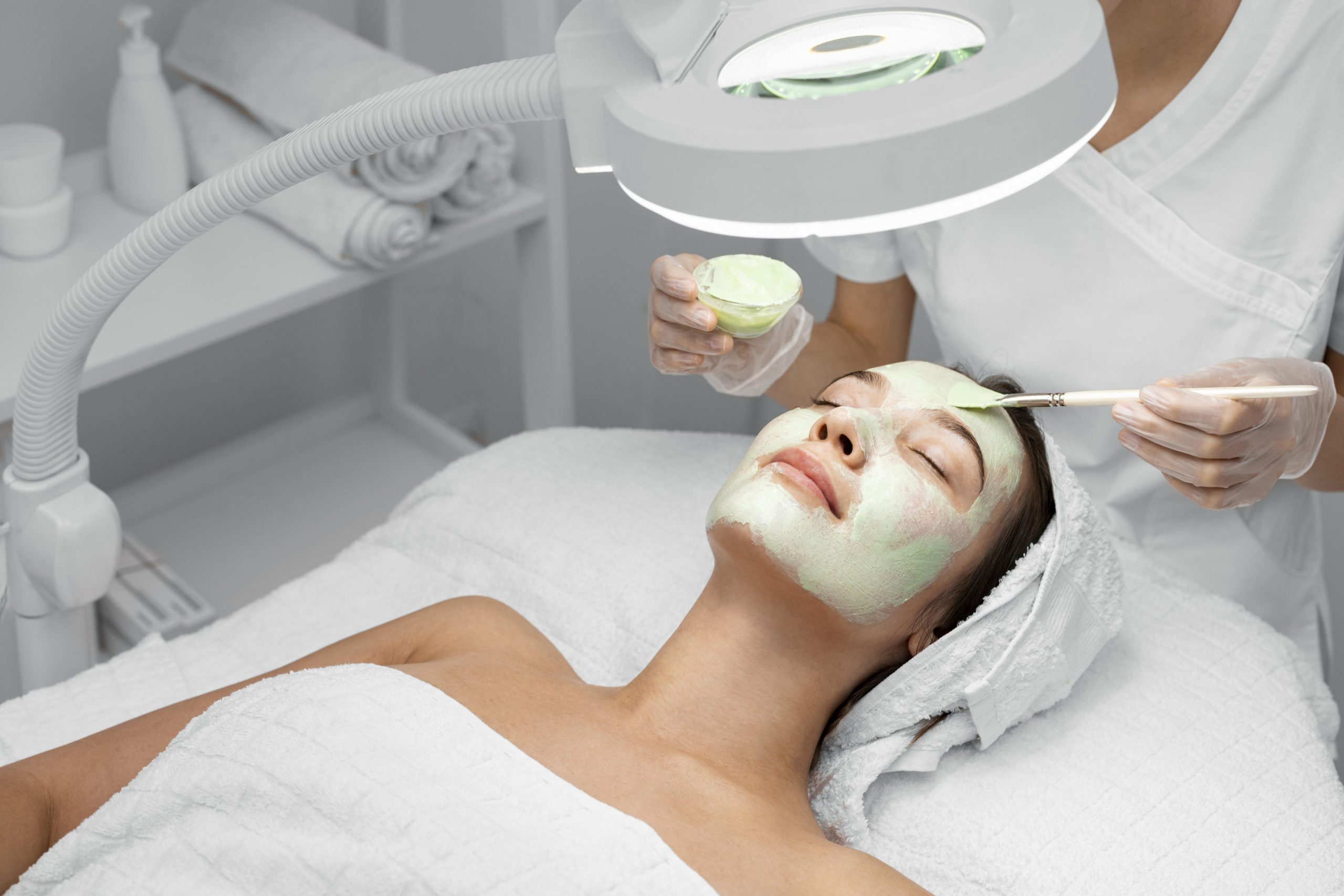 esteticista aplicando mascarilla en clienta